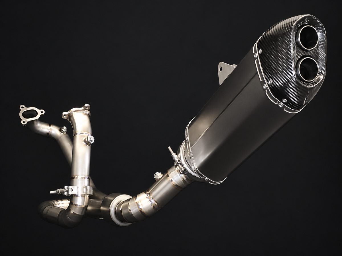 A high-performance exhaust system with a carbon fiber muffler and polished stainless steel pipes, shown against a solid black background.