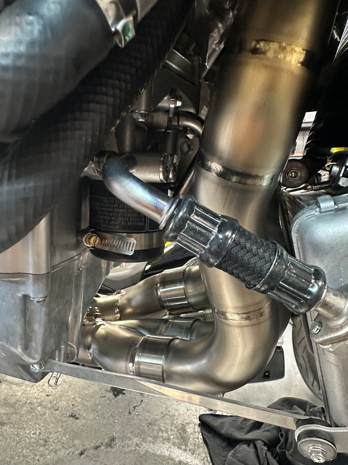 Close-up of a motorcycle exhaust system with metallic pipes and components.