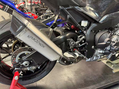 Close-up of a motorcycle with a Vandemon exhaust in a workshop setting