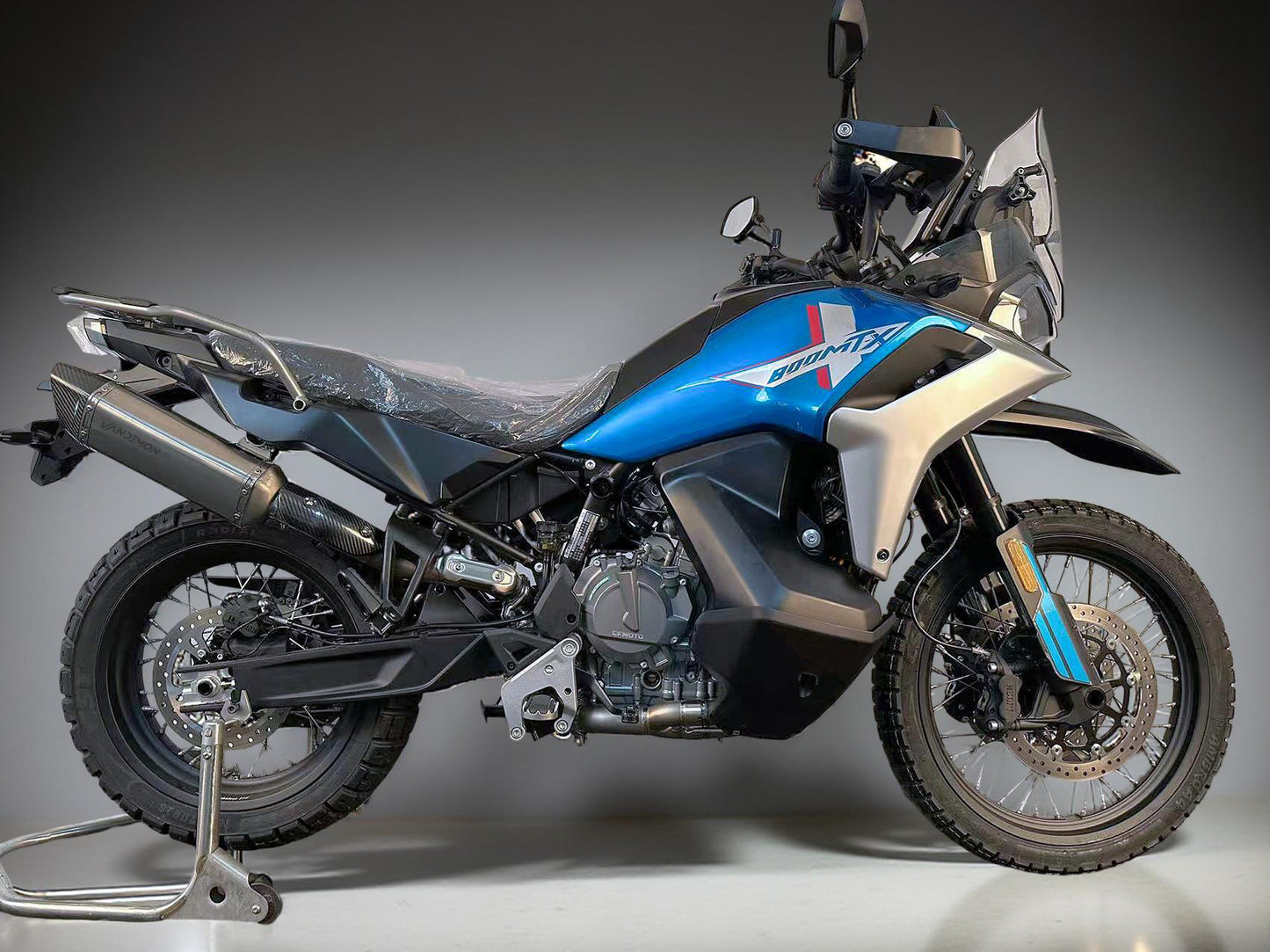 Motorcycle on a stand with a dark background with Vandemon exhaust