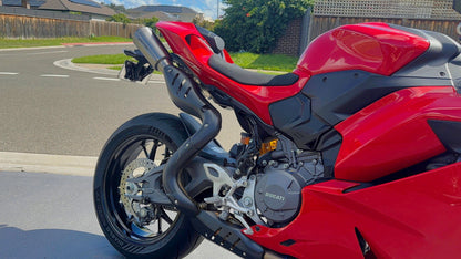 Red and black motorcycle parked on a street with a residential background