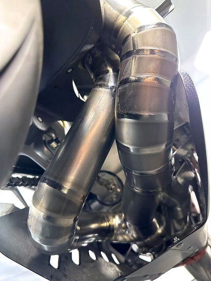 Close-up of a motorcycle exhaust system with a shiny metallic finish.