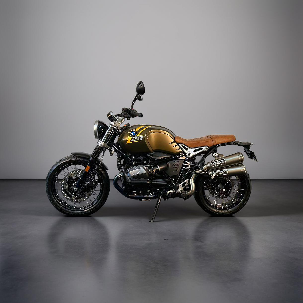 Gold and black BMW motorcycle with brown seat on a grey background