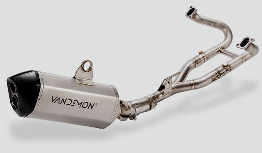 A Vandemon stainless steel exhaust system with a cylindrical muffler and dual header pipes, shown on a light grey background.