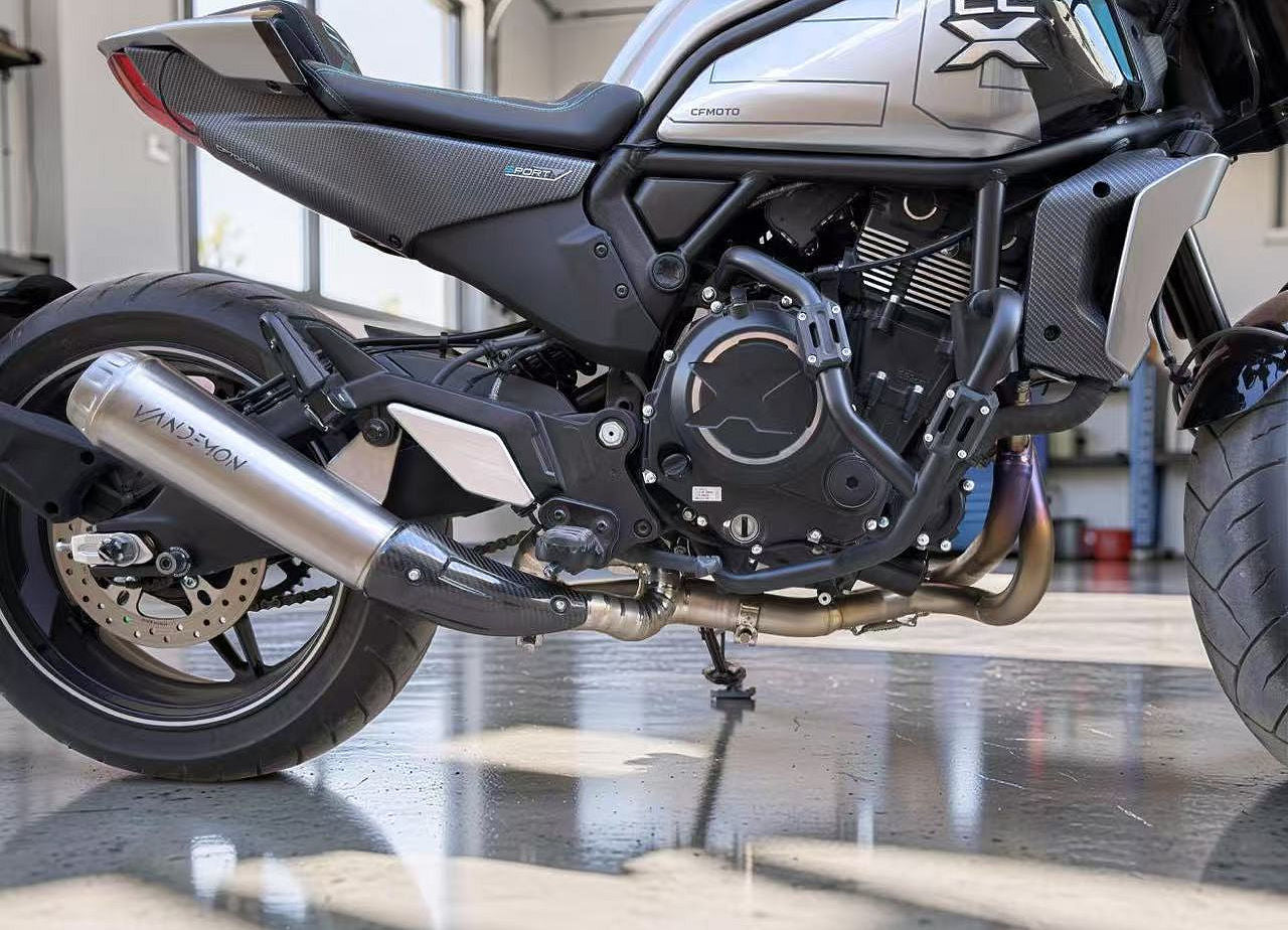 Close-up of a motorcycle engine and exhaust system in a garage setting