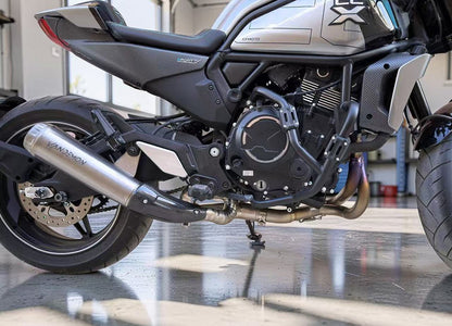 Close-up of a motorcycle engine and exhaust system in a garage setting