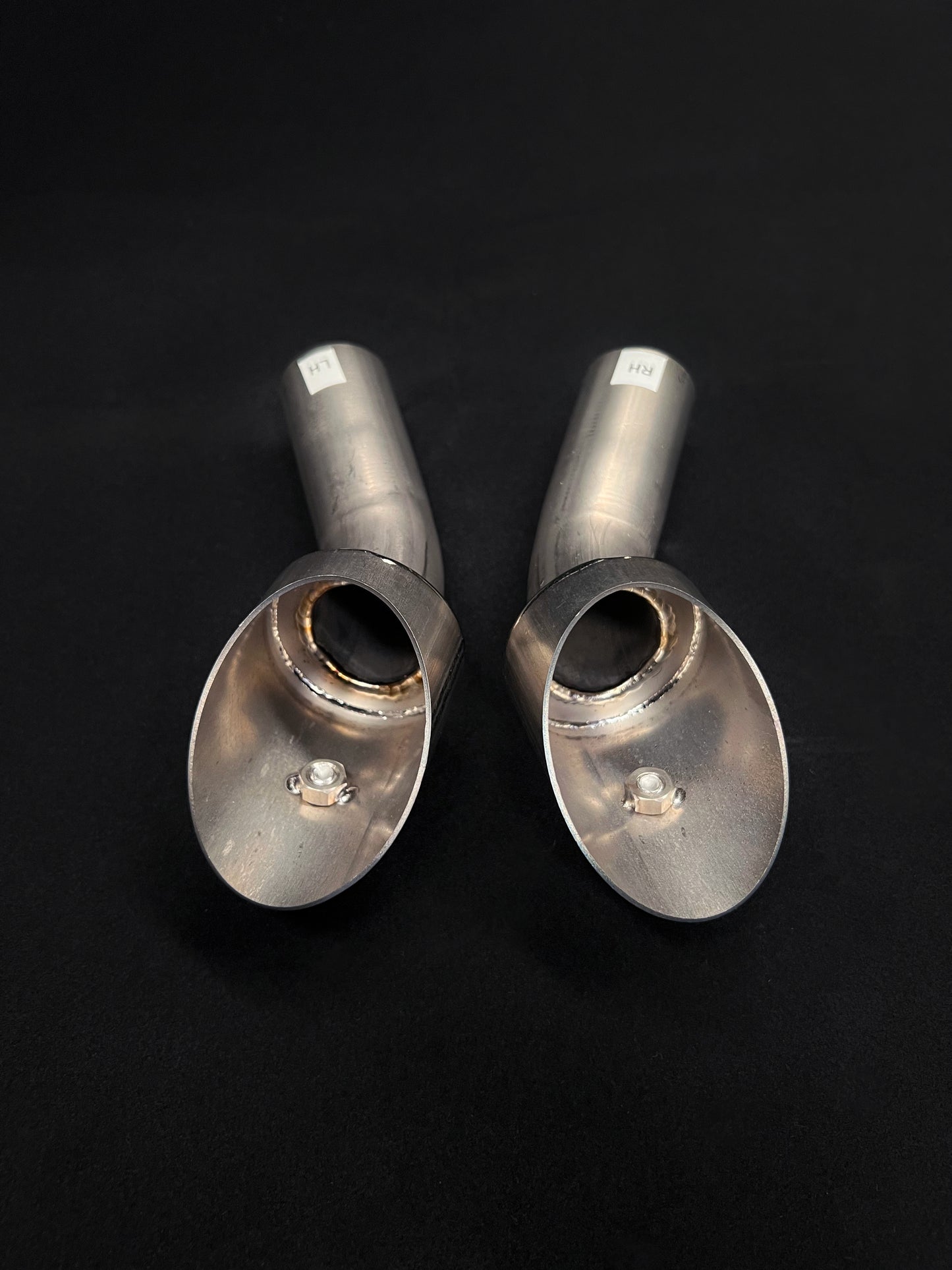 Two metallic exhaust tips on a black background