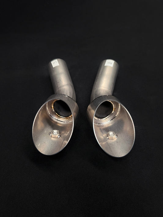 Two metallic exhaust tips on a black background
