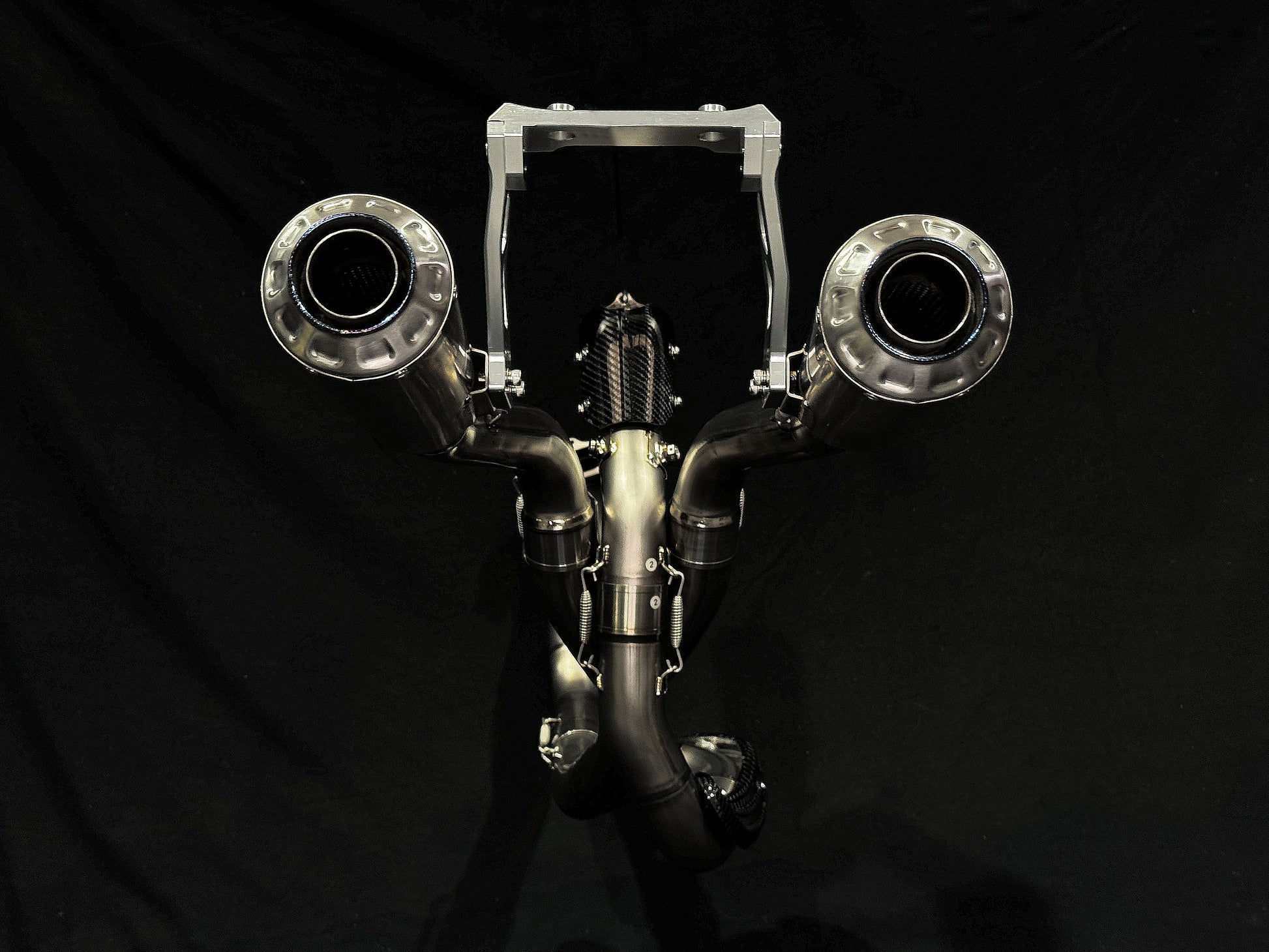 A motorcycle's high mount titanium rear mufflers.