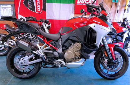 Red and black motorcycle on display with a Ducati banner in the background