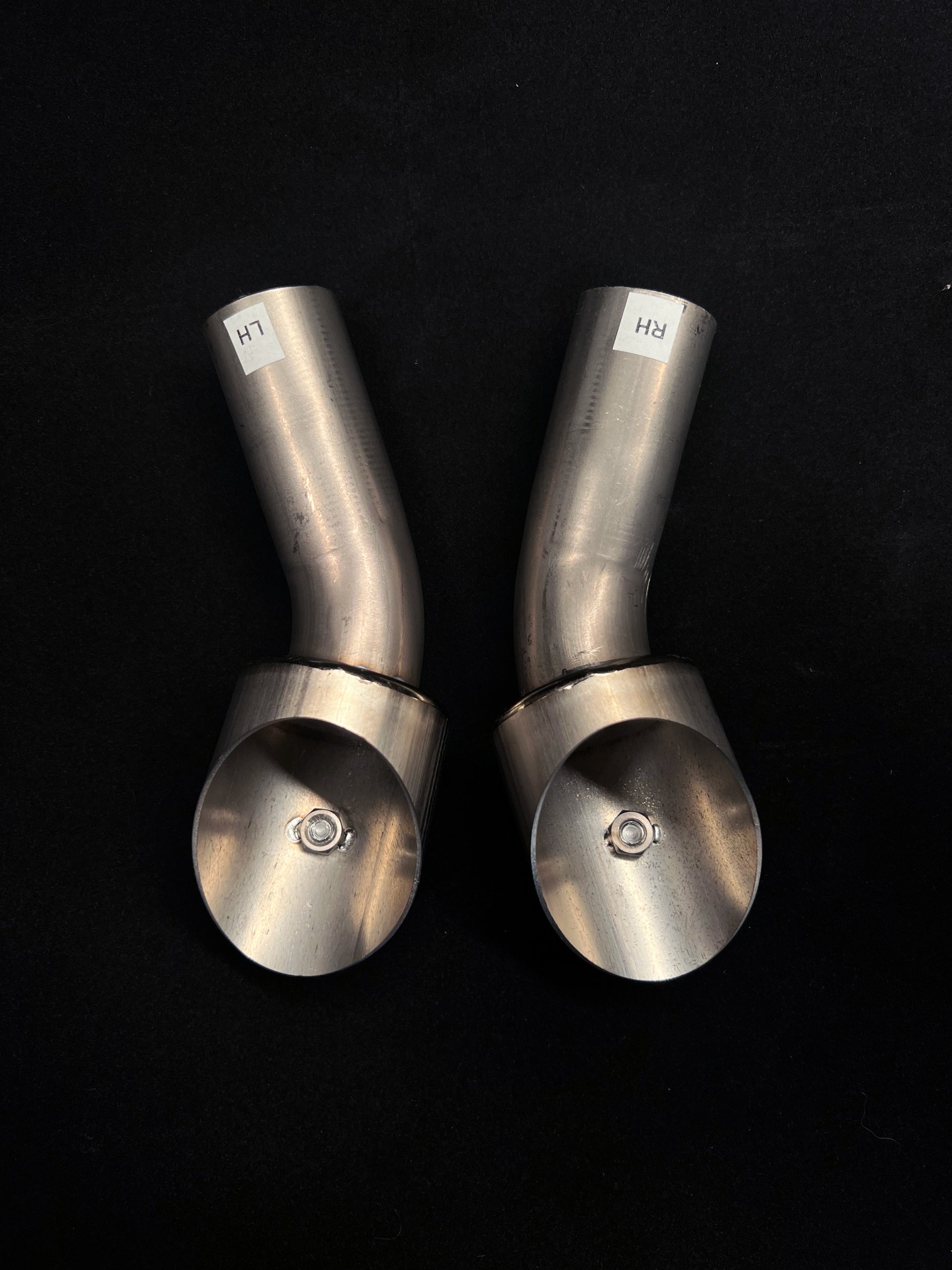 Two metallic cylindrical objects with rounded ends on a black background
