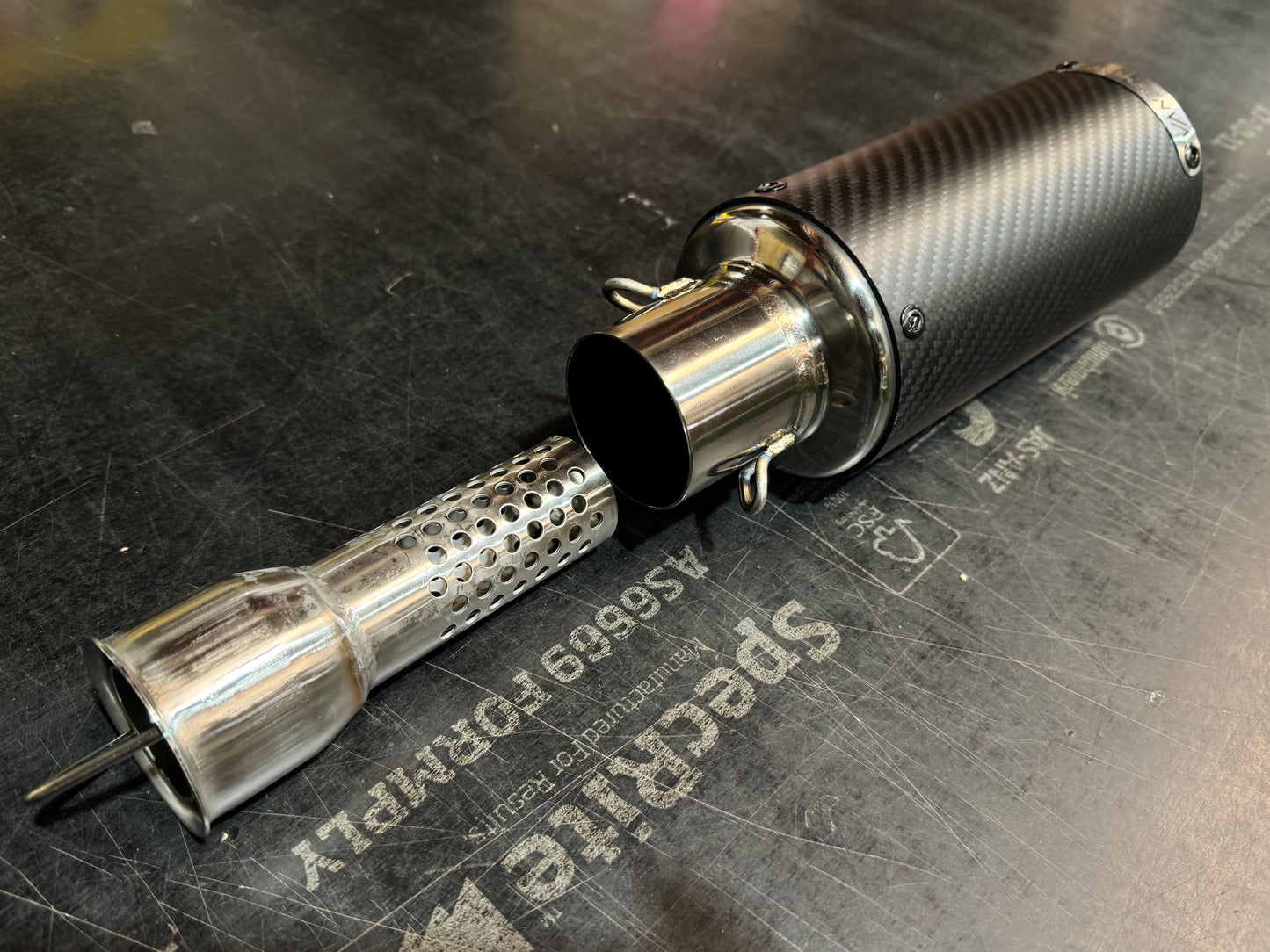 Metal exhaust pipe on a textured metal surface