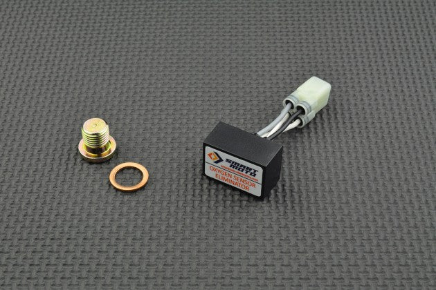 Mechanical components, including a bolt, washer, and electronic module, on a textured grey surface.