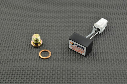 Mechanical components including a black actuator, gold screw, and copper washer on a grey textured background.