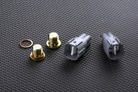 Set of automotive connectors and bolts on a textured grey surface