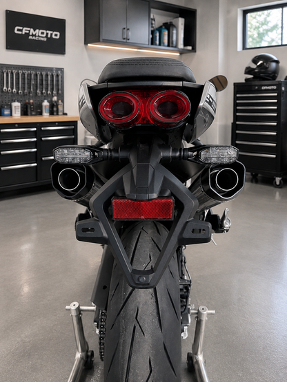 Rear view of a black Ducati motorcycle on a stand in a clean garage workshop.