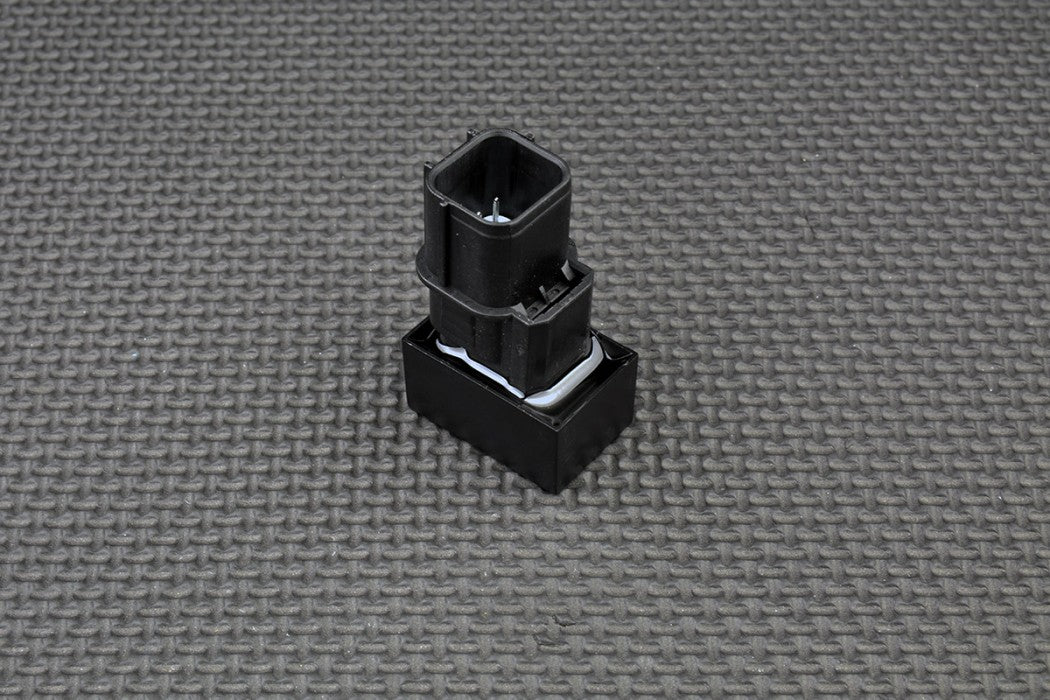 Black plastic component on a grey textured background