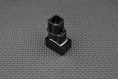 Black plastic component on a grey textured background