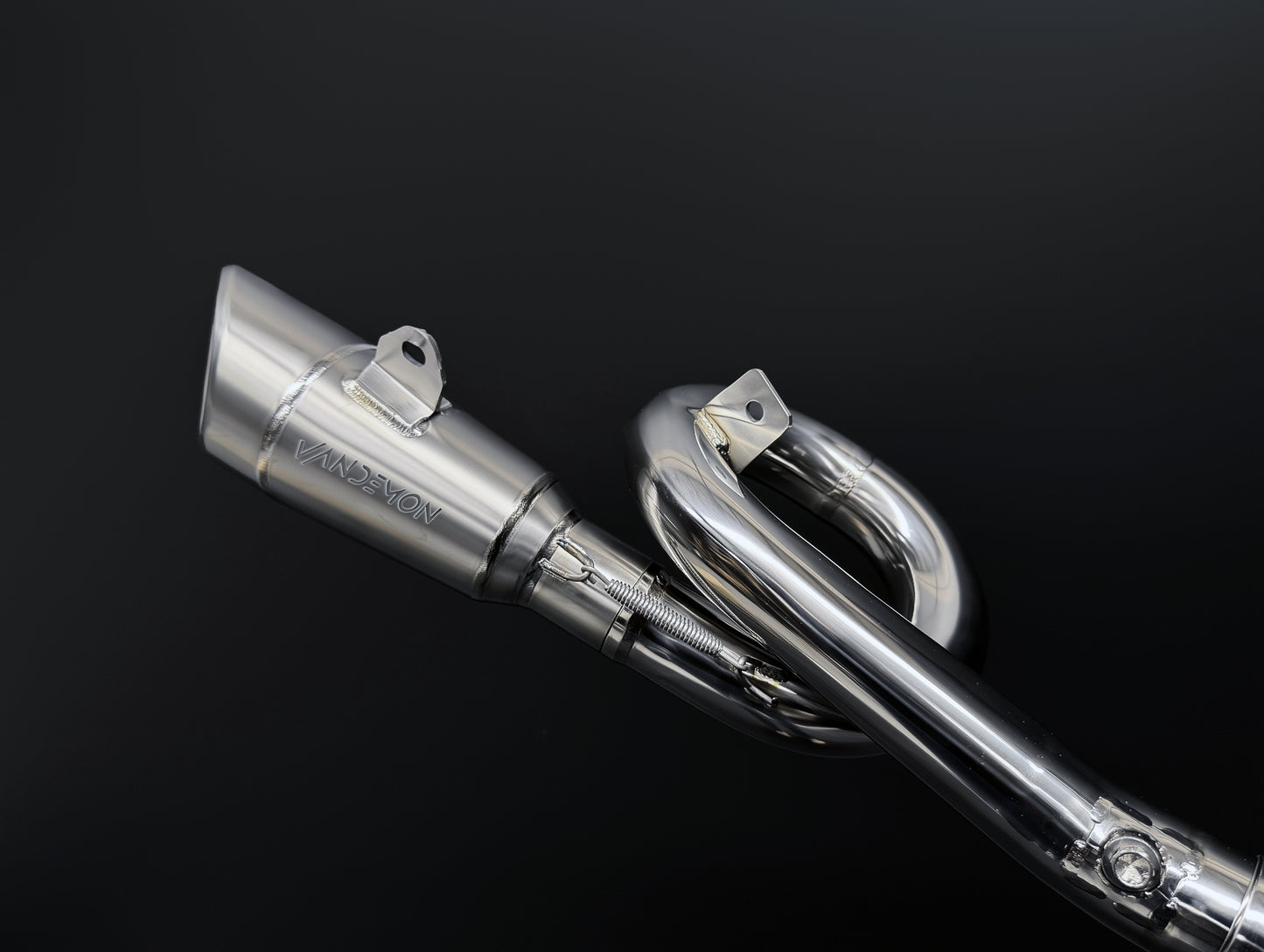 Close-up of a Vandemon motorcycle exhaust system on a black background