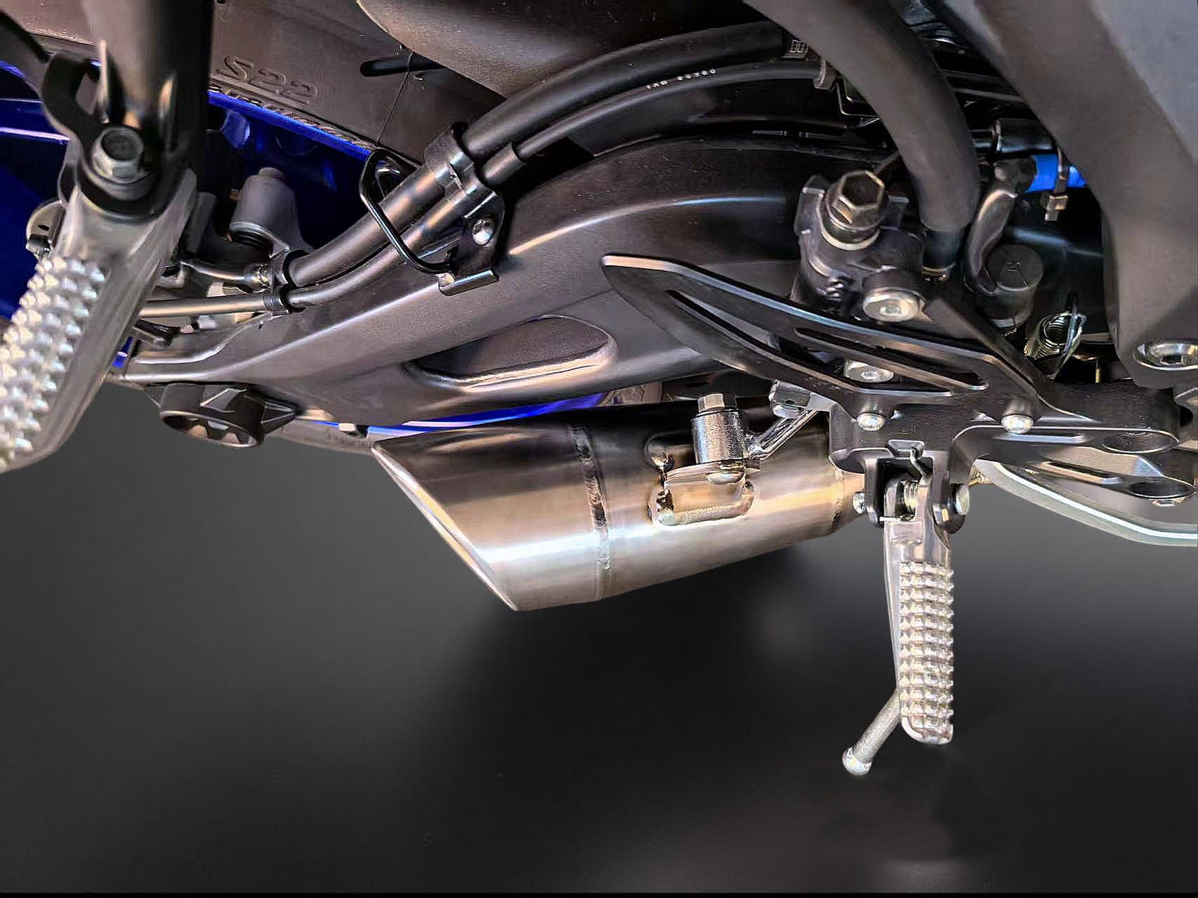 Close-up of a motorcycle's exhaust and suspension system on a dark background
