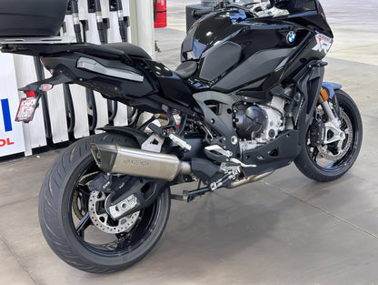 Black BMW motorcycle on a showroom floor with Vandemon exhaust