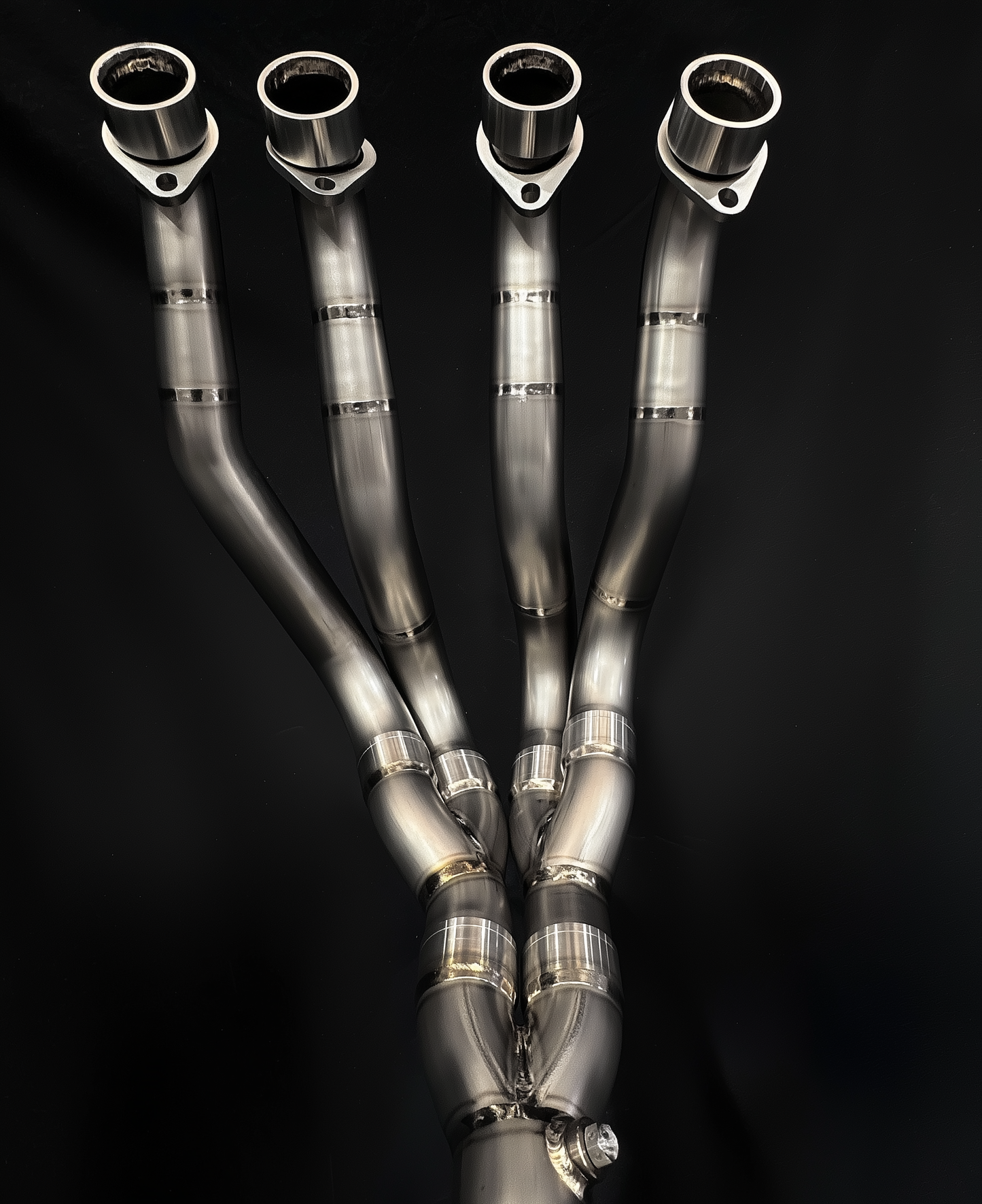 Set of metallic exhaust pipes on a black background