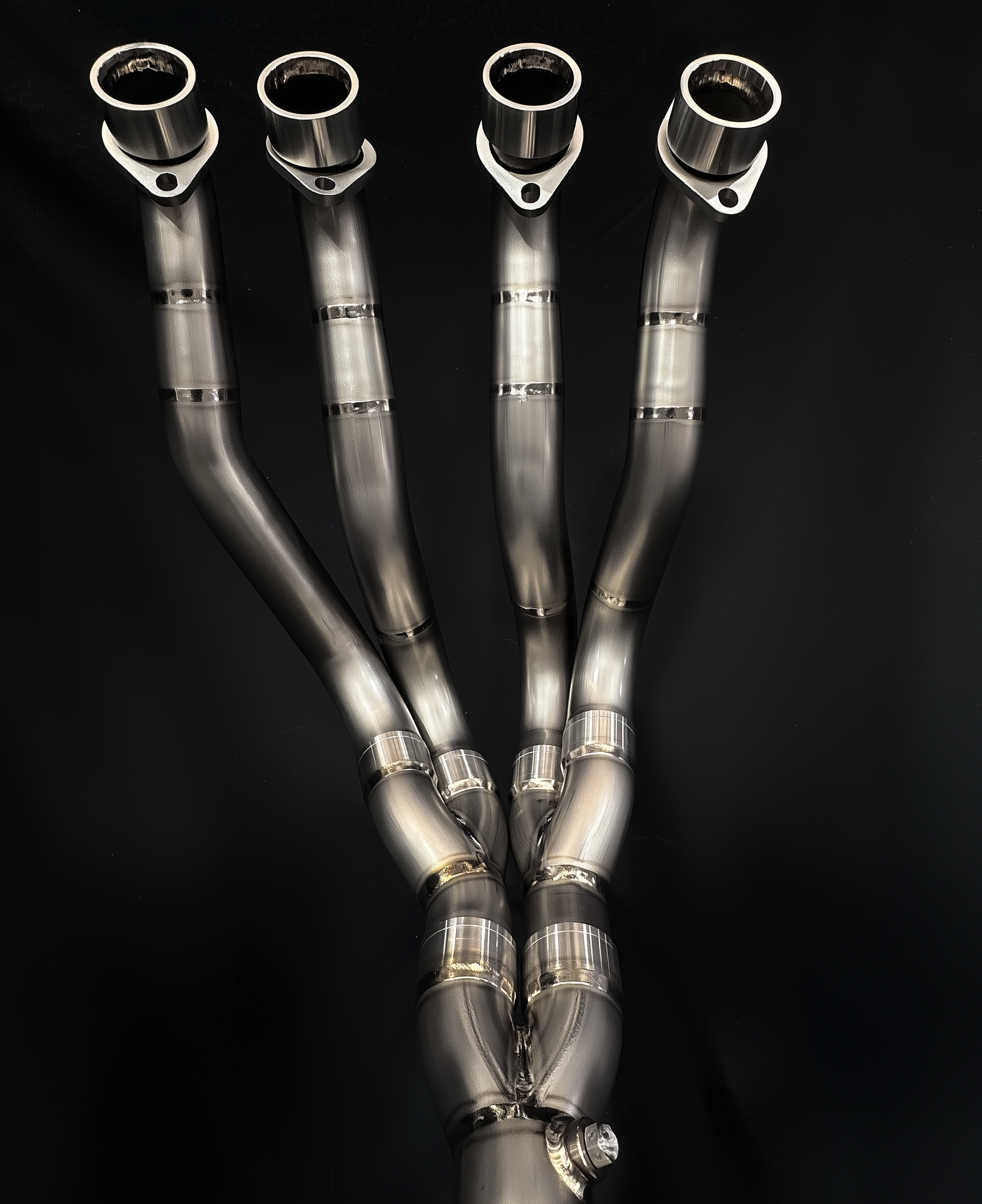 Set of metallic exhaust pipes on a black background