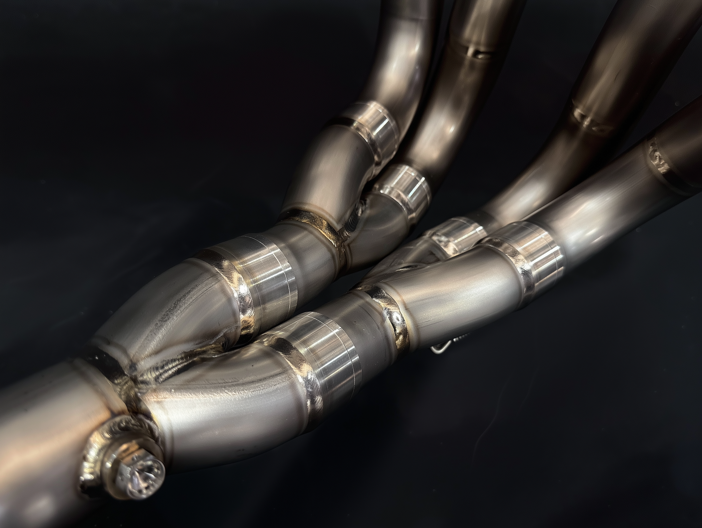 Close-up of metallic exhaust pipes on a dark background
