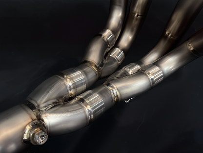 Close-up of metallic exhaust pipes on a dark background